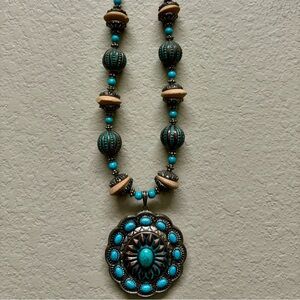 Necklace turquoise and beige stones on a copper silver plate.